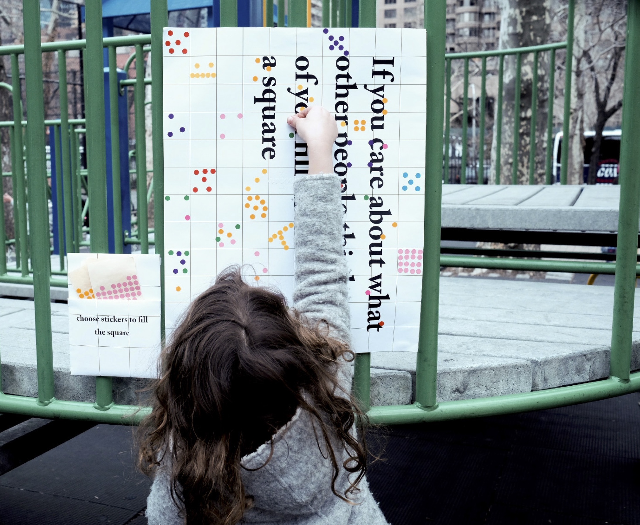 A participant adds a mark to the poster in the park.